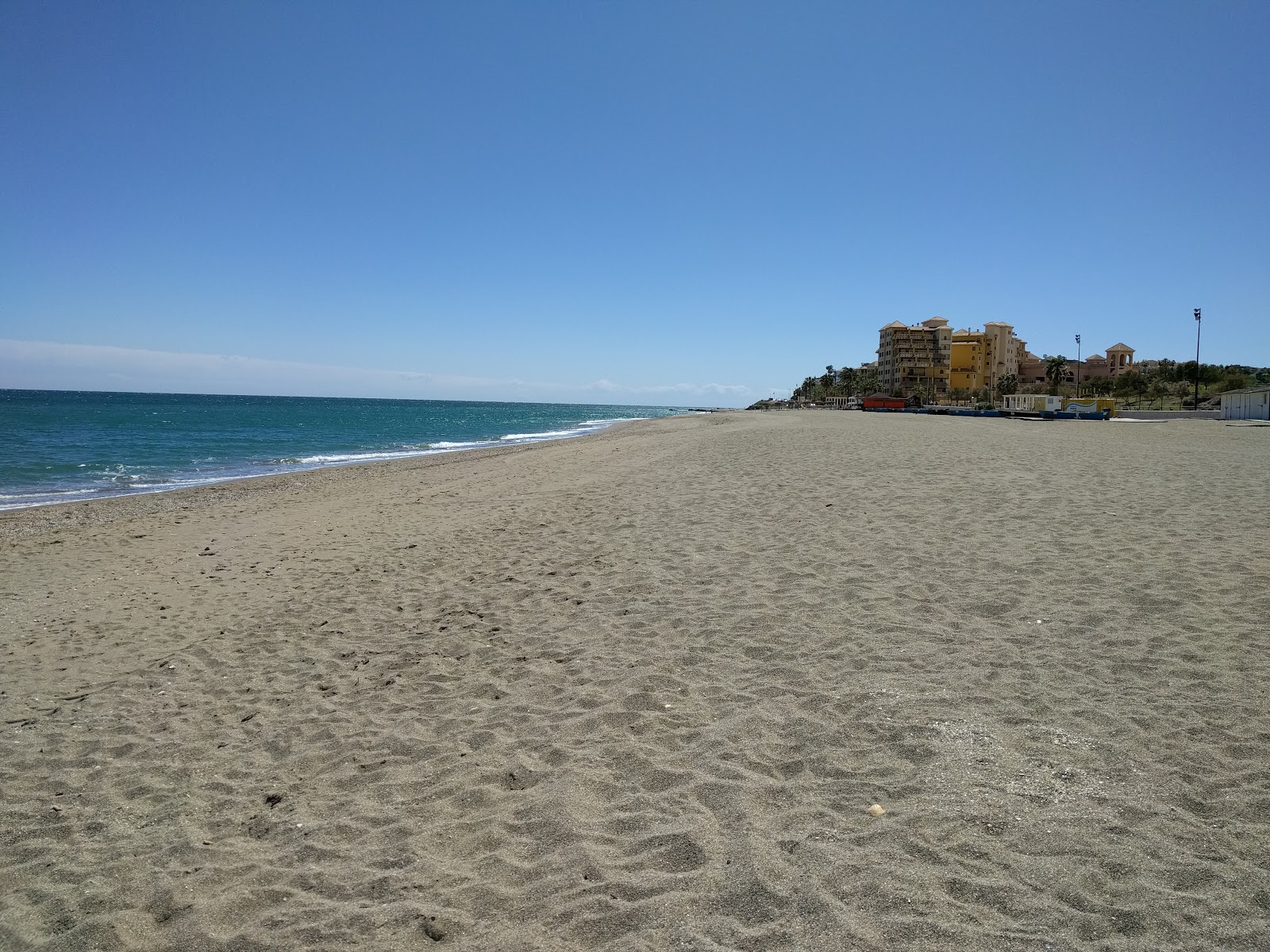 Foto di Playa del Castillo Sohail con una superficie del sabbia grigia