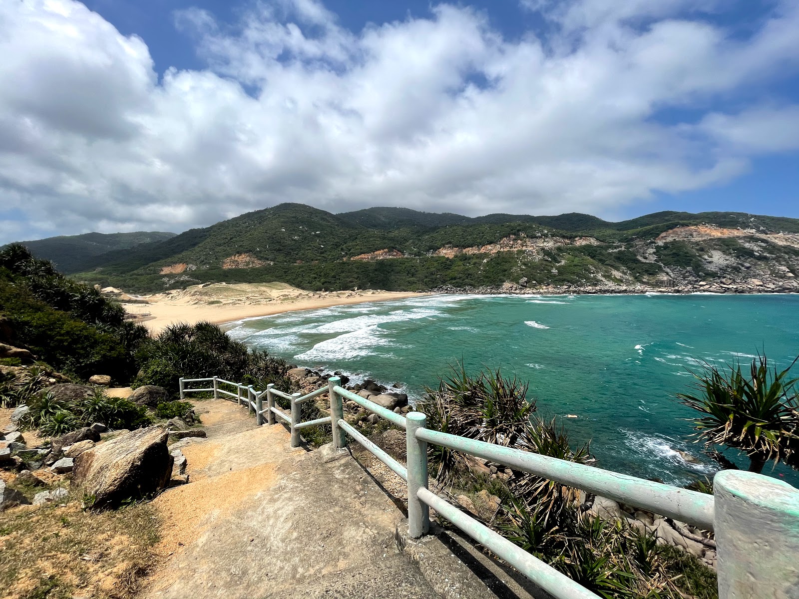 Photo de Bai-Mon Beach protégé par des falaises