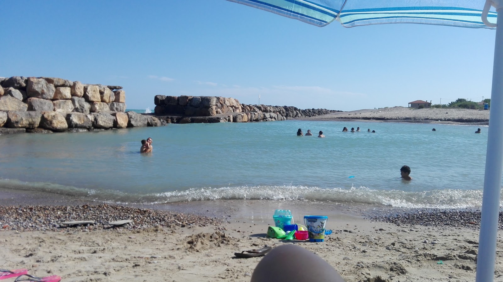 Foto di Playa Serratella con una superficie del acqua marrone