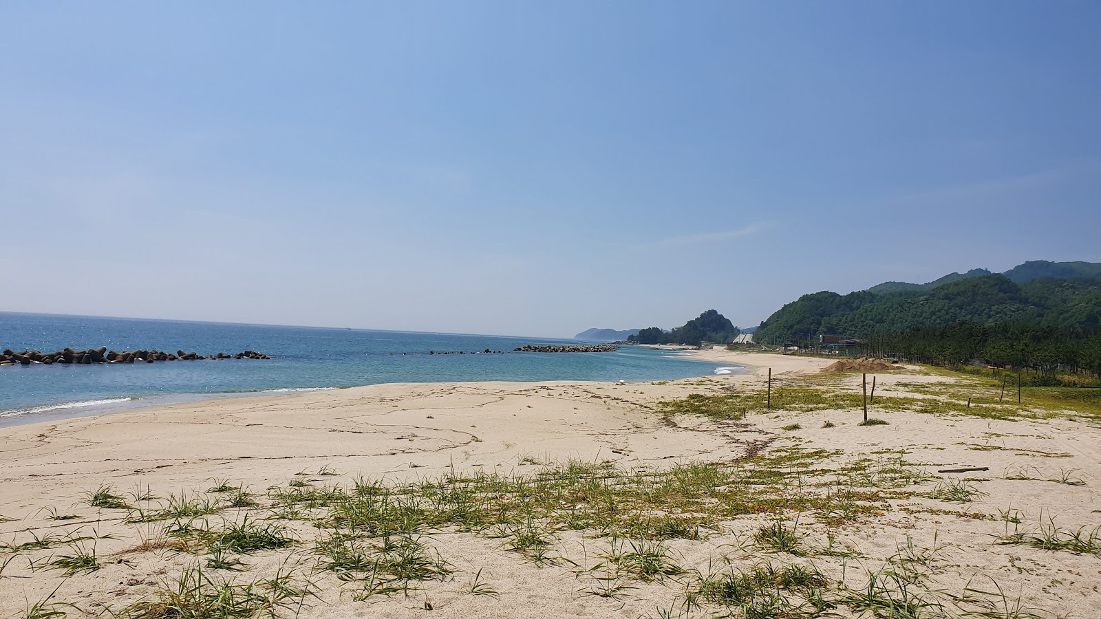 Foto av Deoksin Beach med beige sand yta