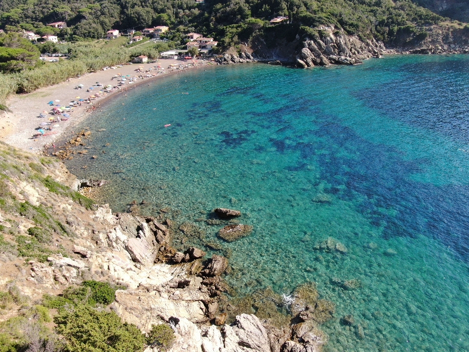 Foto di Spiaggia di Nisportino con una superficie del ciottoli marroni