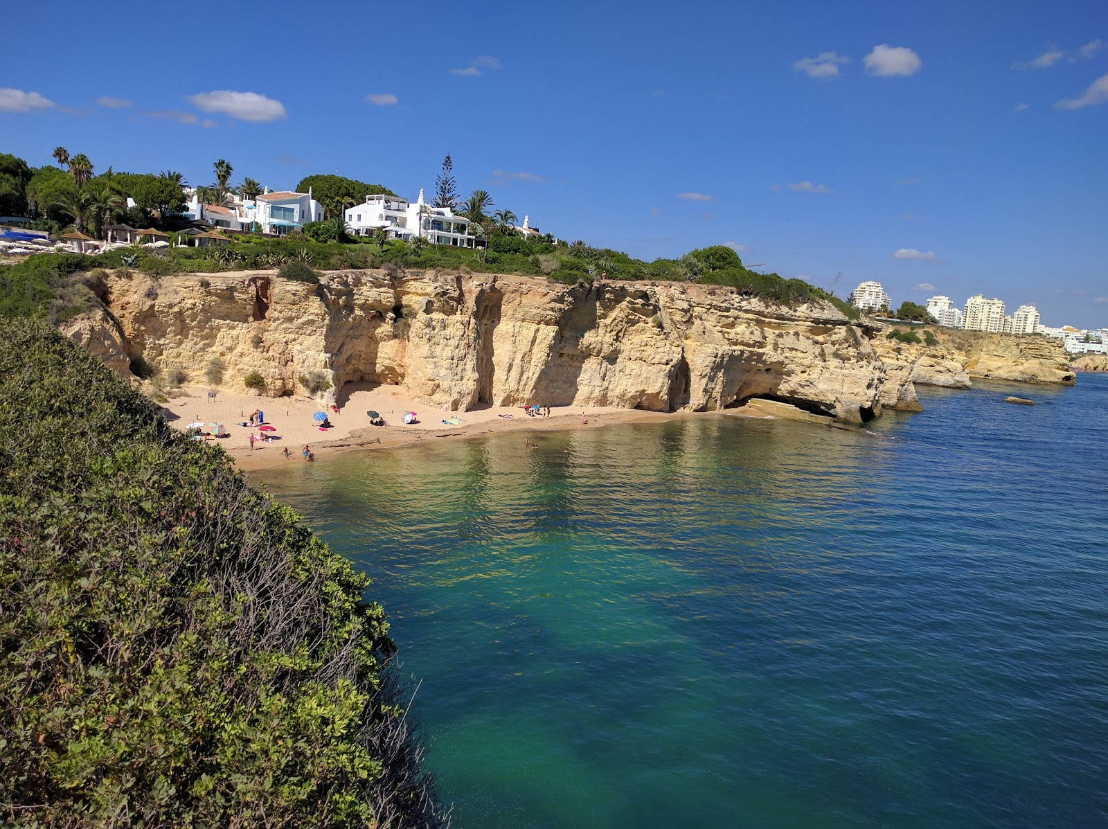 Foto di Praia dos Tremocos con una superficie del sabbia pura scura