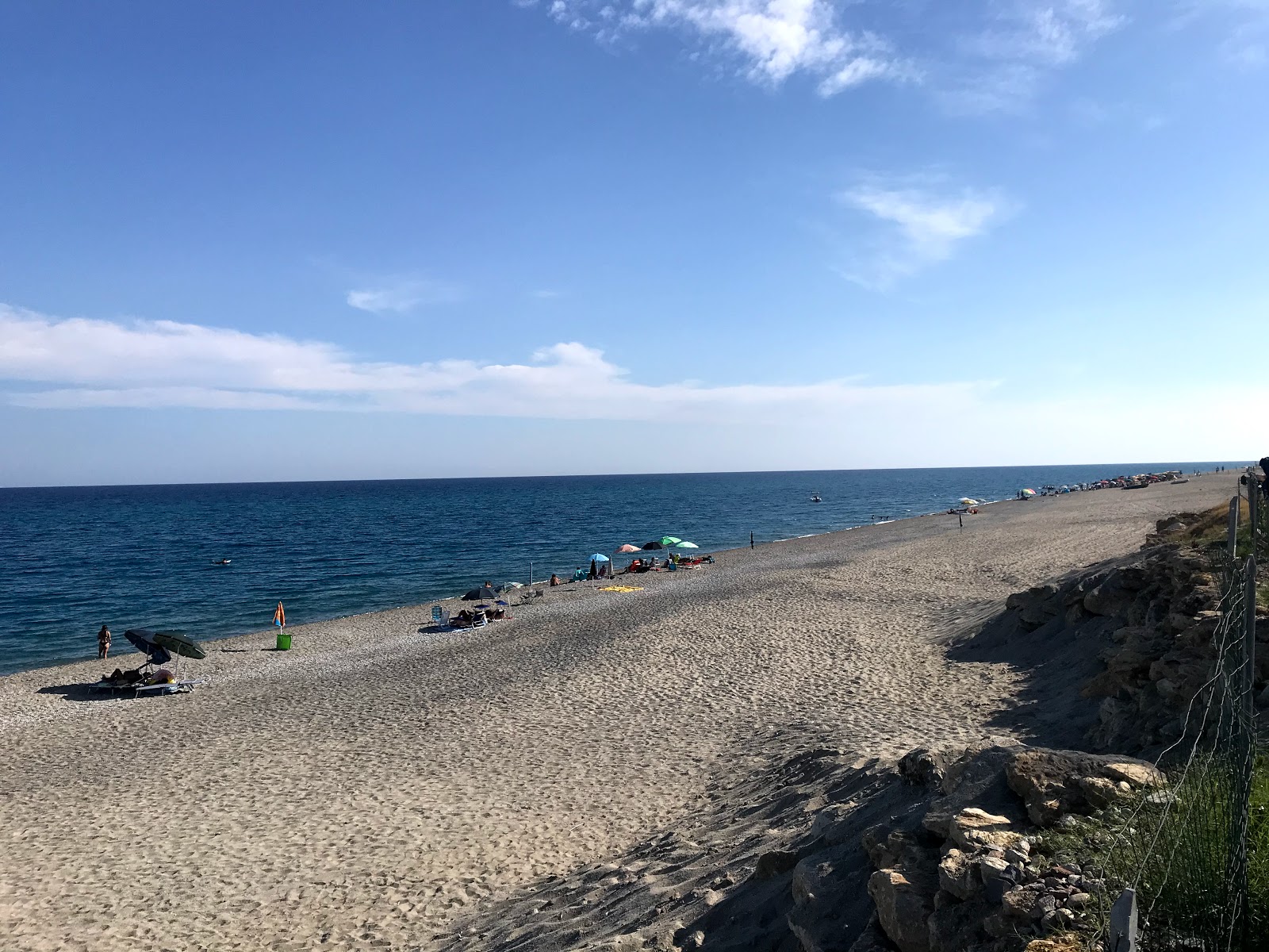 Torre Ellera beach'in fotoğrafı koyu i̇nce çakıl yüzey ile