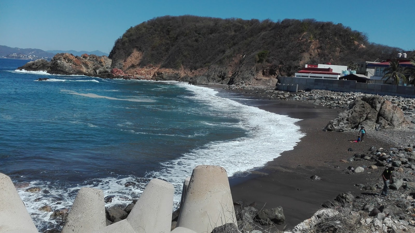 Photo of Playa Ventanas with brown sand &  rocks surface