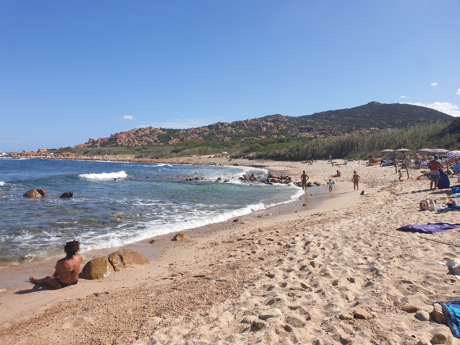 Fotografie cu Spiaggia di Cala Canneddi cu o suprafață de nisip beige și pietre