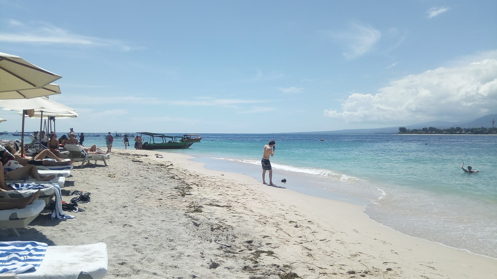 Foto de Gili Indah Beach con arena brillante y rocas superficie