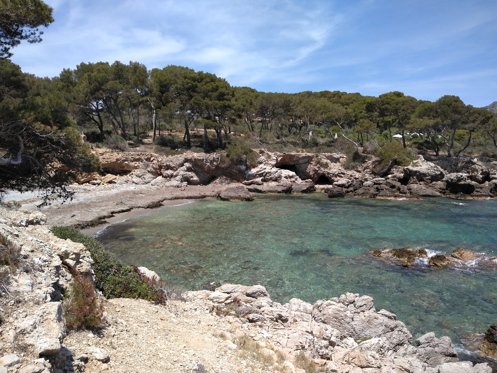 Photo of Cala Auberdans with brown fine pebble surface