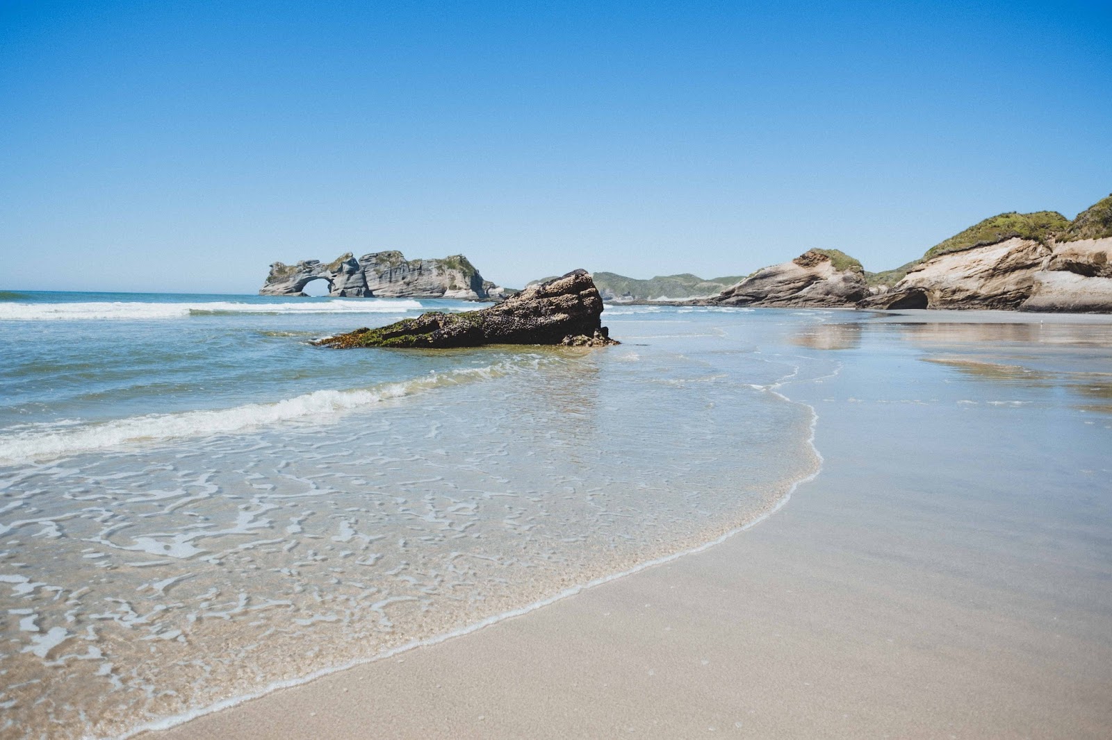 Foto van Wharariki Beach ondersteund door kliffen