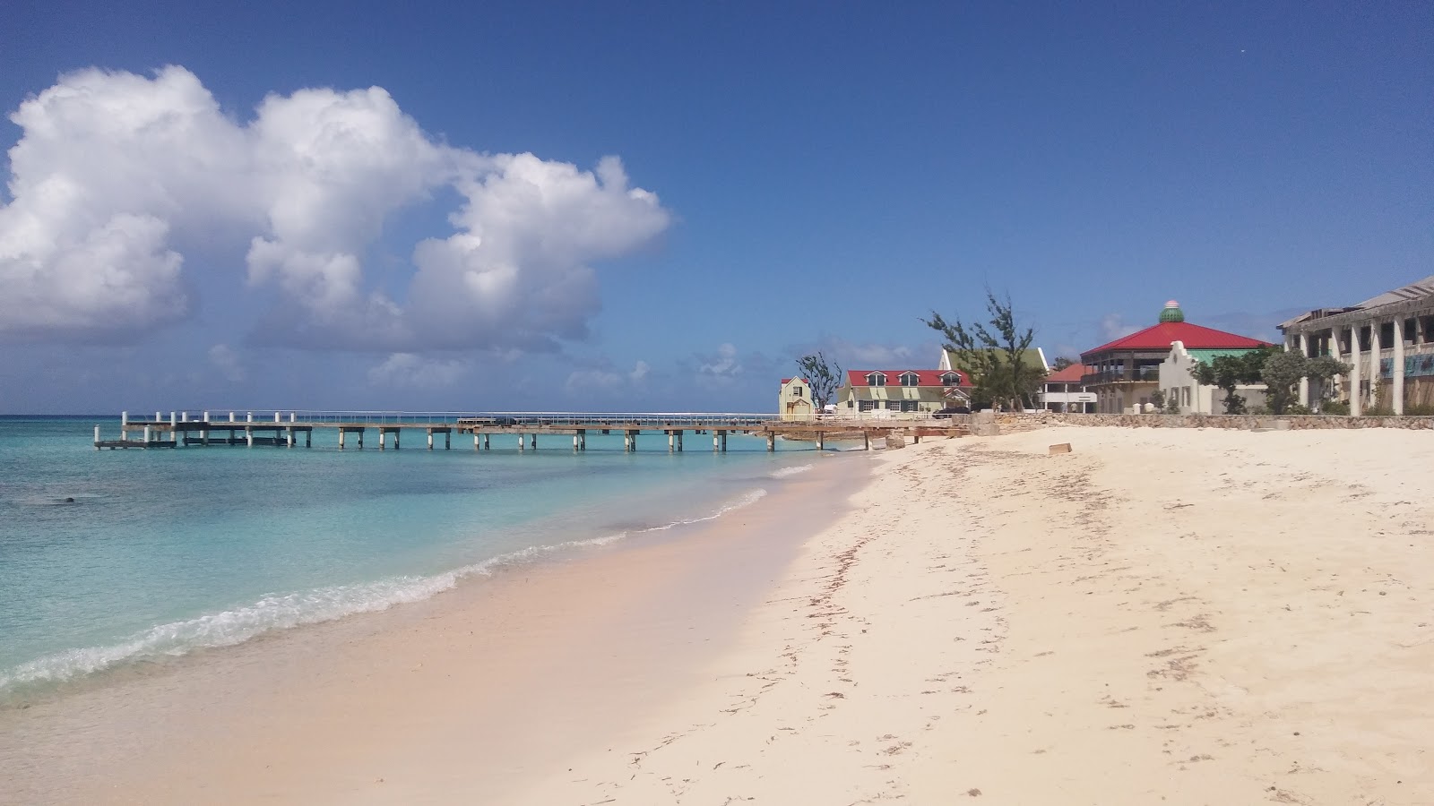 Photo of Cockburn Town beach with turquoise pure water surface