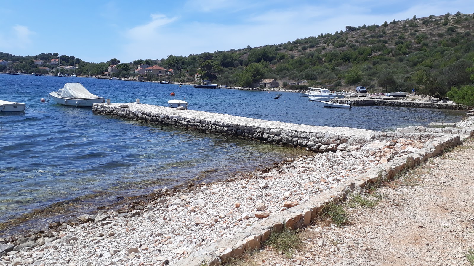 Porto Rosso beach的照片 带有轻质细卵石表面