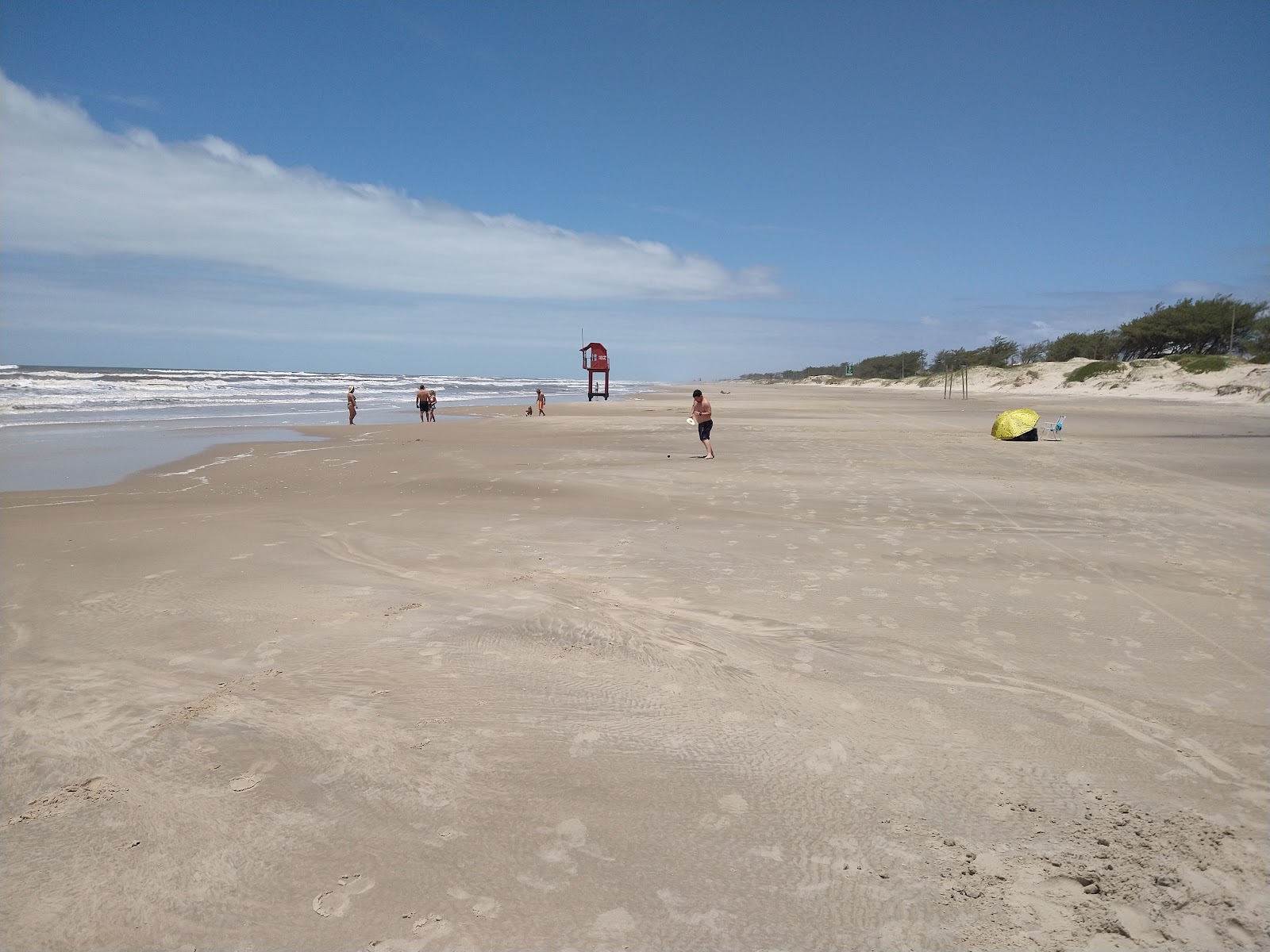 Valokuva Uusi Tramandai-rantaista. pinnalla kirkas hiekka:n kanssa