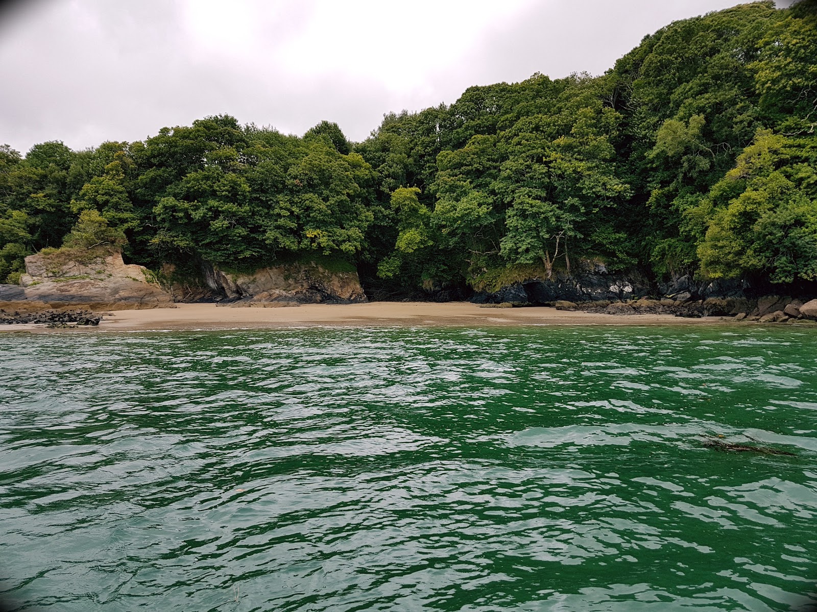 Foto van Praia de Centrona omringd door bergen