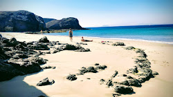 Valokuva Playa de la Ceraista. ympäröity vuorilla