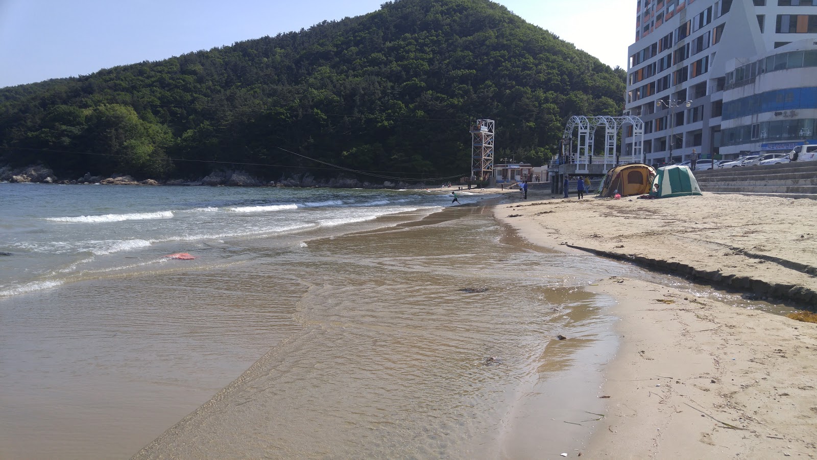 Φωτογραφία του Deokpo Beach με τυρκουάζ νερό επιφάνεια