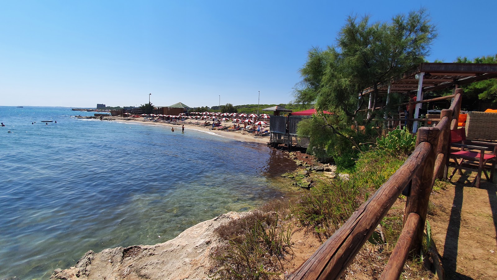 Valokuva Spiaggia di Torre Specchiaista. pinnalla sininen puhdas vesi:n kanssa