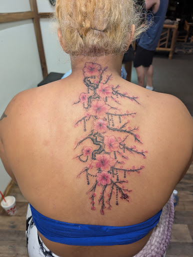 Find tattoo ideas between breast for your next unique tattoo in Cornelia at Prismatic Pulse Tattoo