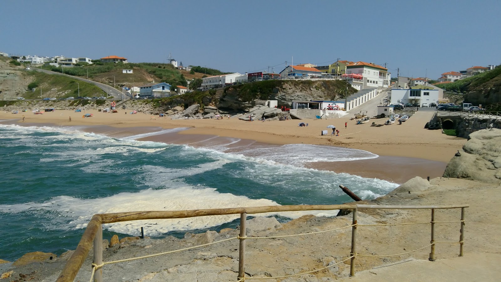 Foto von Praia de Porto Dinheiro von Klippen umgeben