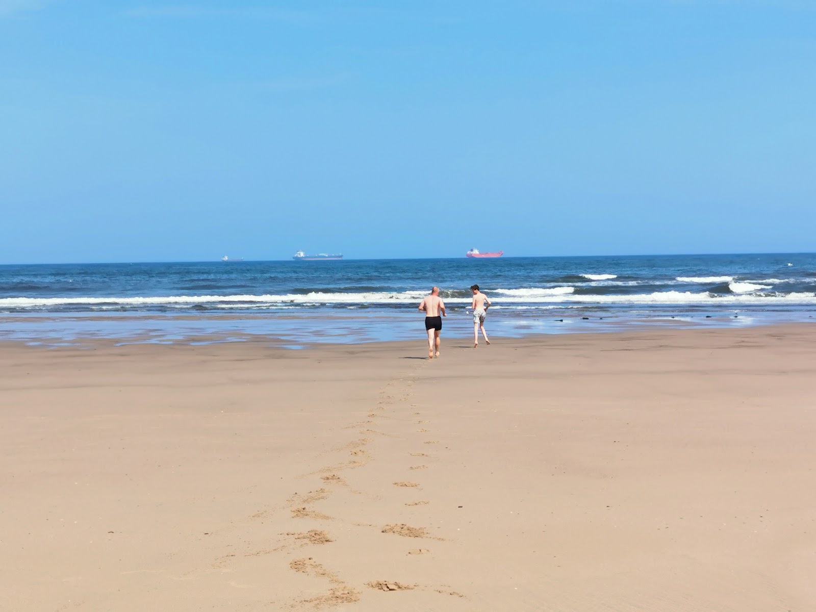 Crimdon beach的照片 带有碧绿色纯水表面