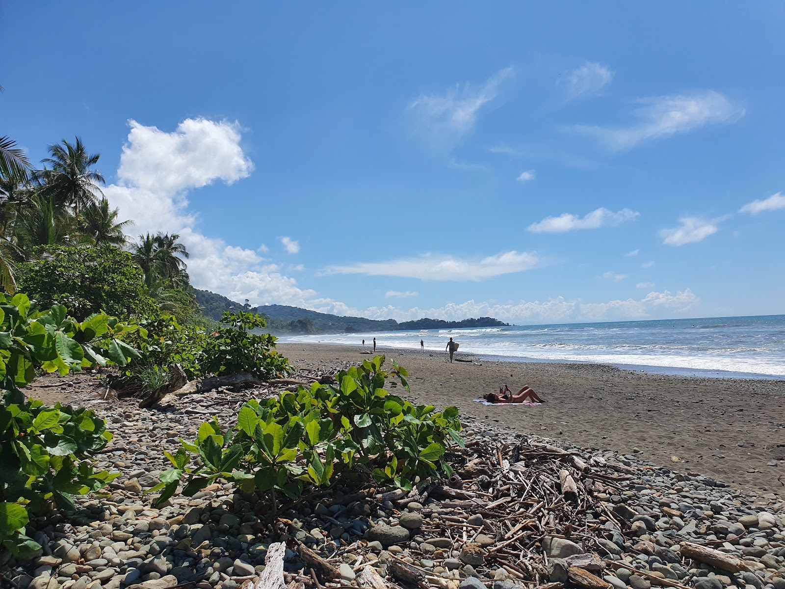 Foto de Playa Dominical com areia cinza e rochas superfície