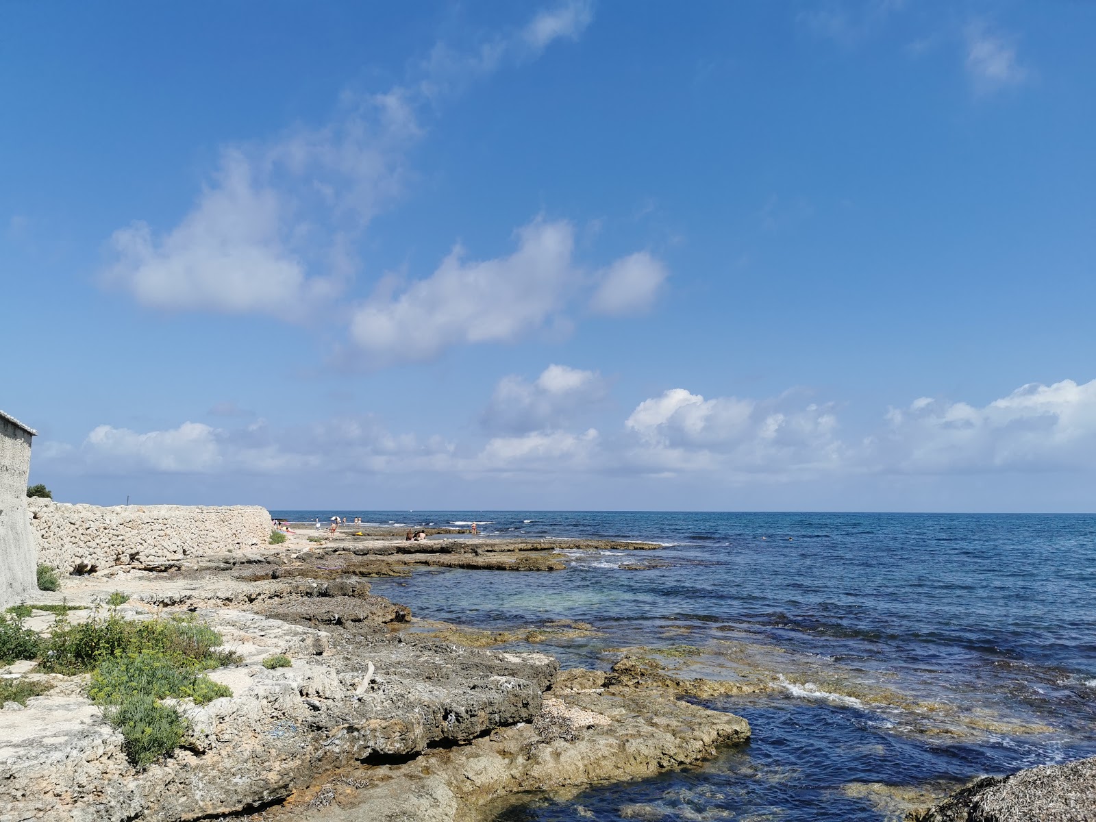 Foto de Libera blue wings beach con arena gris y piedras superficie