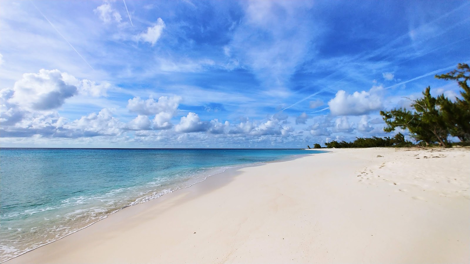 Zdjęcie Norman Saunders beach z powierzchnią jasny, drobny piasek