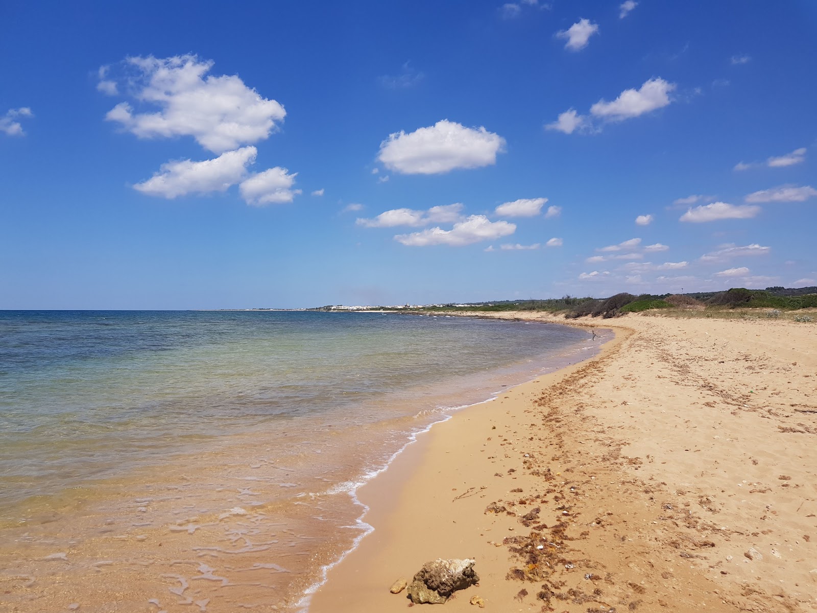 Foto von Spiaggia dell'Isola della Fanciulla mit beiger sand & steine Oberfläche