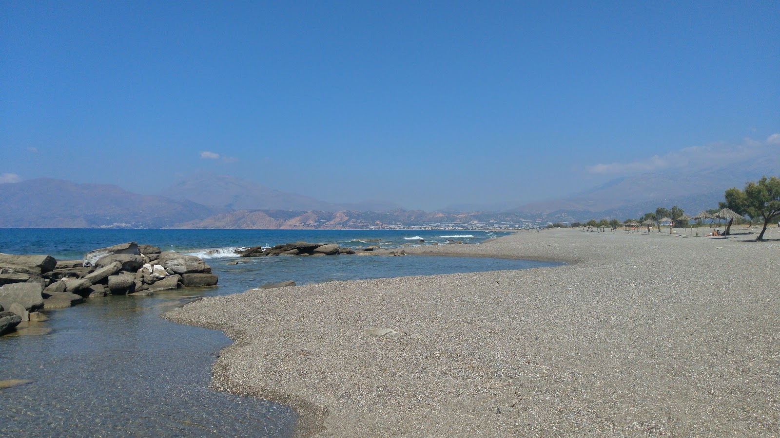Foto di Afrathias beach con una superficie del piccoli ciottoli grigi
