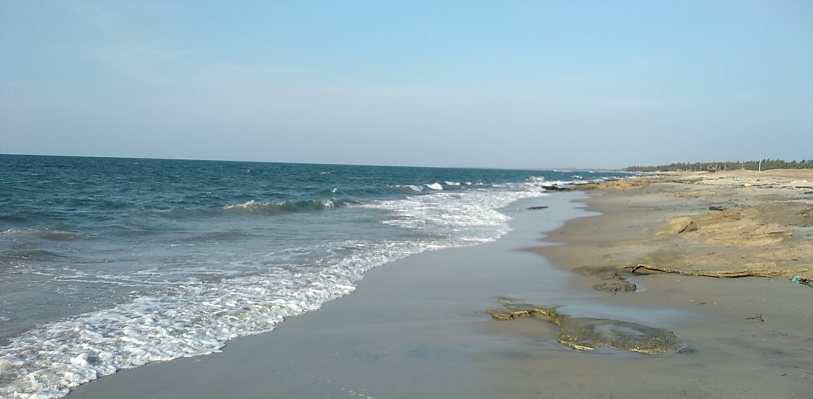 Valokuva Pudumadam Beachista. pinnalla kirkas hiekka:n kanssa