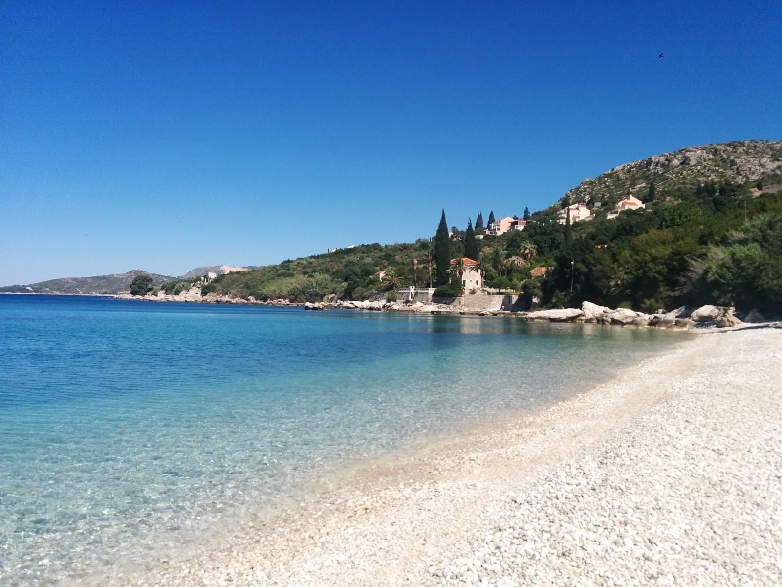 Foto von Plat beach mit beiger kiesel Oberfläche