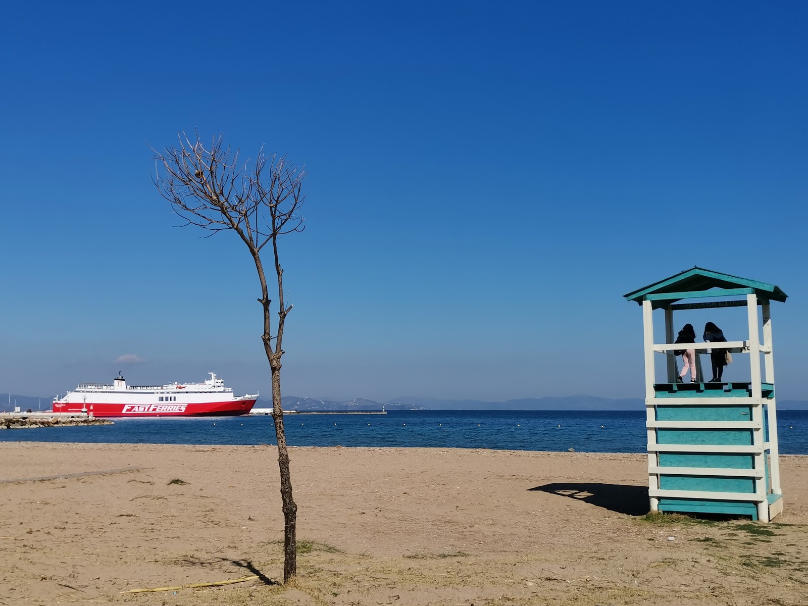 Foto di Paralia Rafinas Port con una superficie del acqua verde chiaro