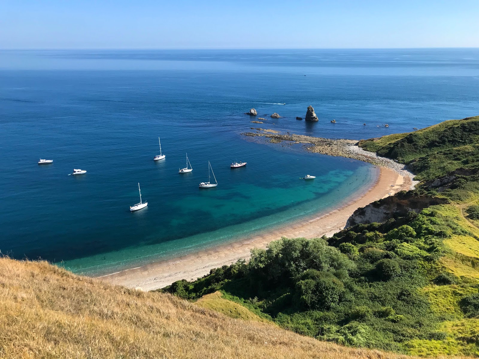 Zdjęcie Mupe Bay beach z powierzchnią beżowe kamyki
