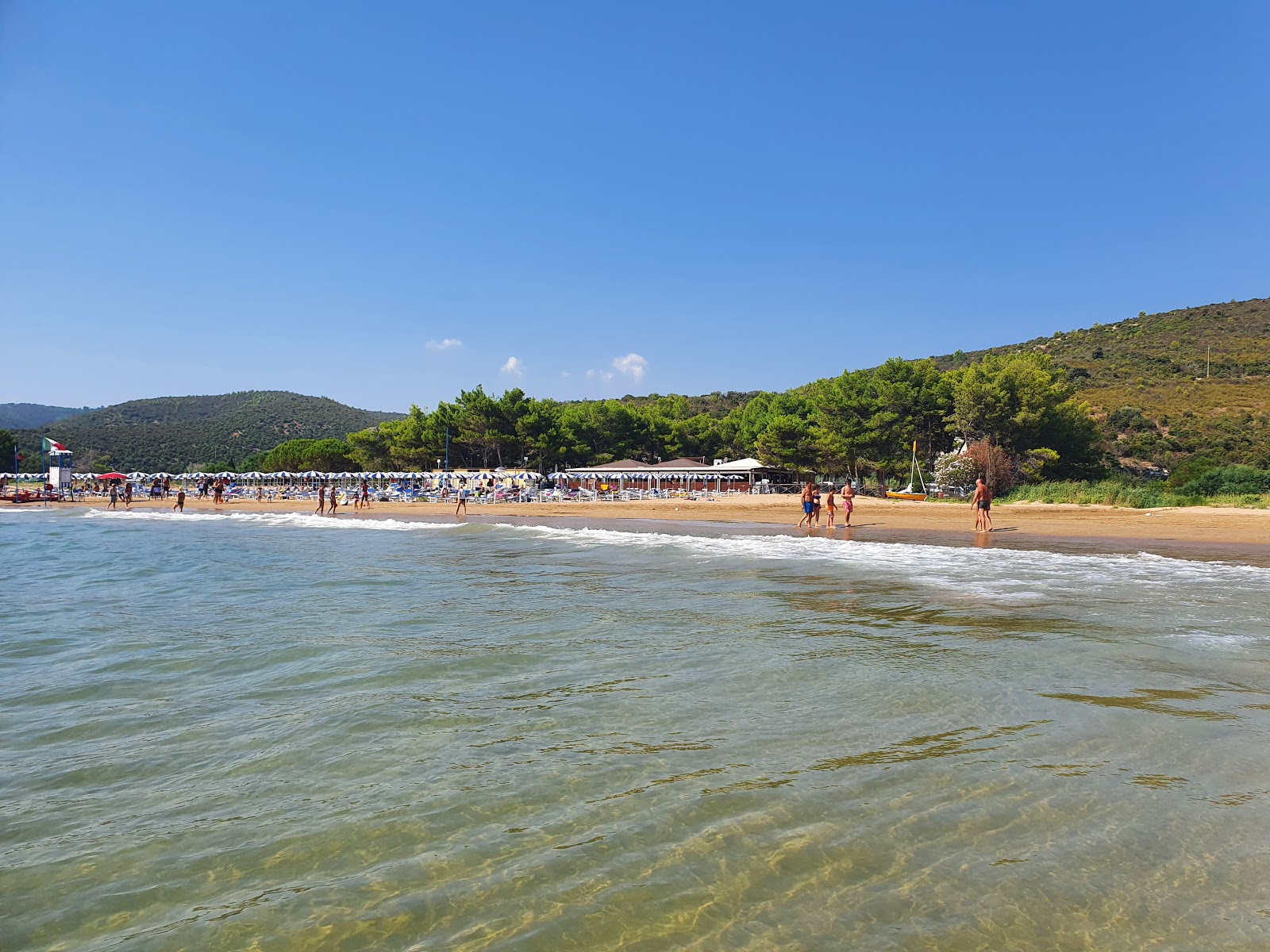 Foto av Spiaggia di Portonuovo omgiven av klippor