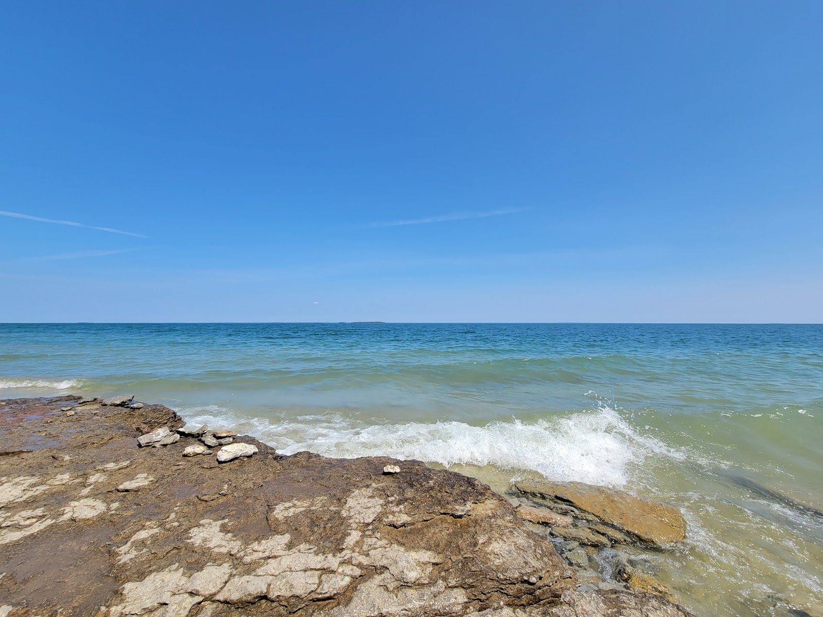 Valokuva Fossil Ledges Beachista. pinnalla turkoosi puhdas vesi:n kanssa