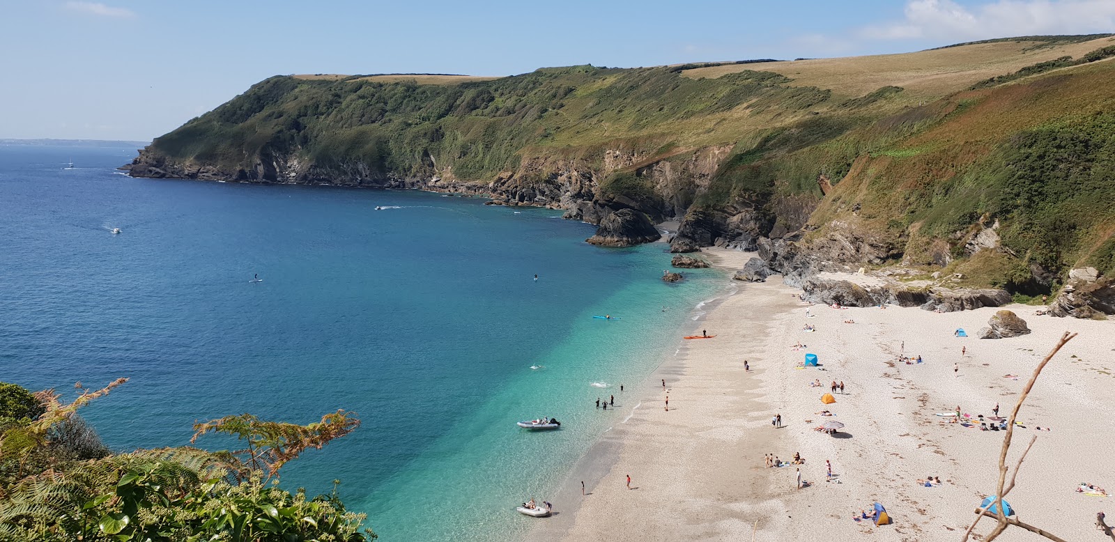 Φωτογραφία του Lantic Bay με μικρά μπεζ βότσαλα επιφάνεια