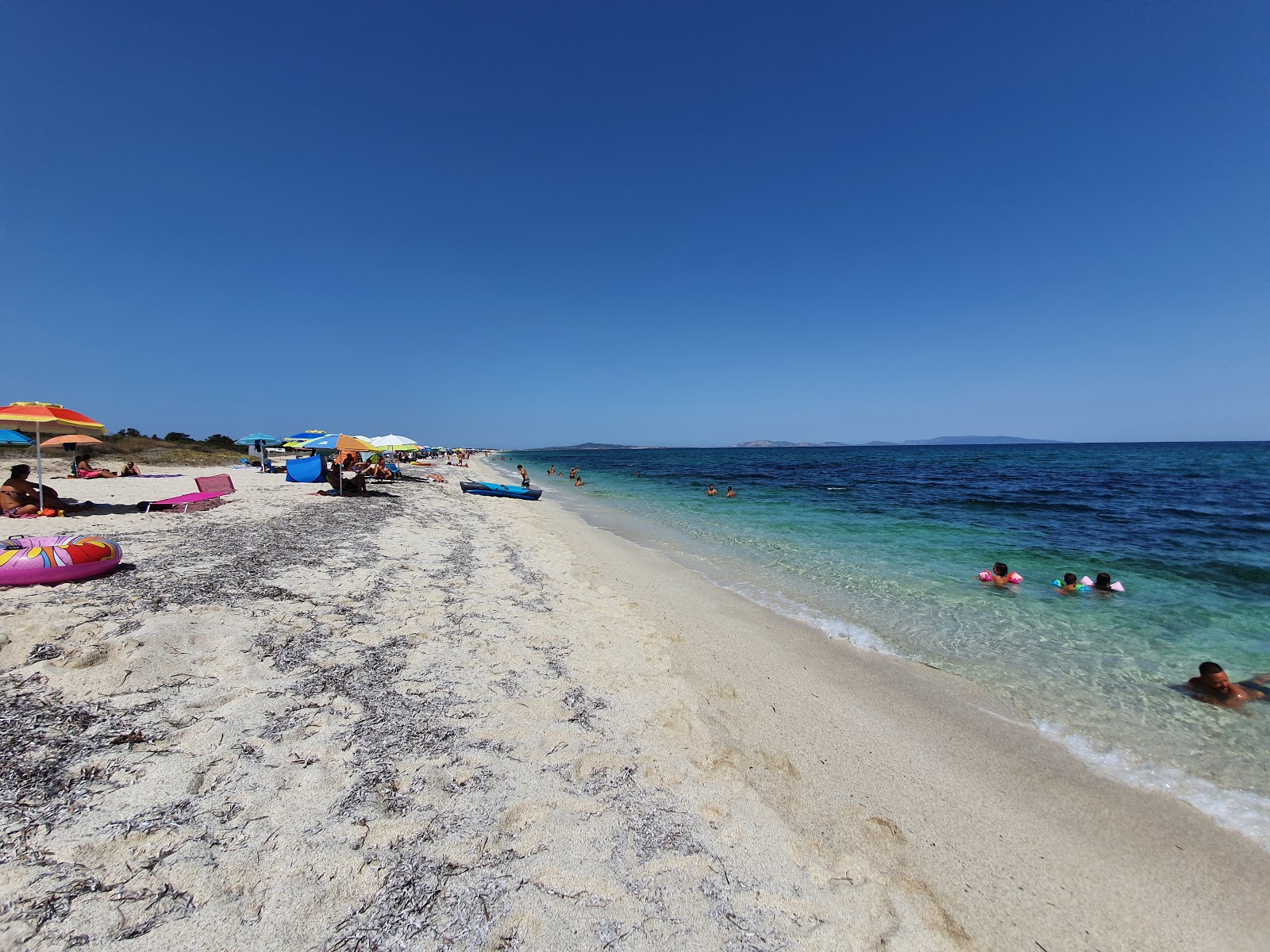 Foto van Spiaggia di Stagno di Pilo met turquoise puur water oppervlakte