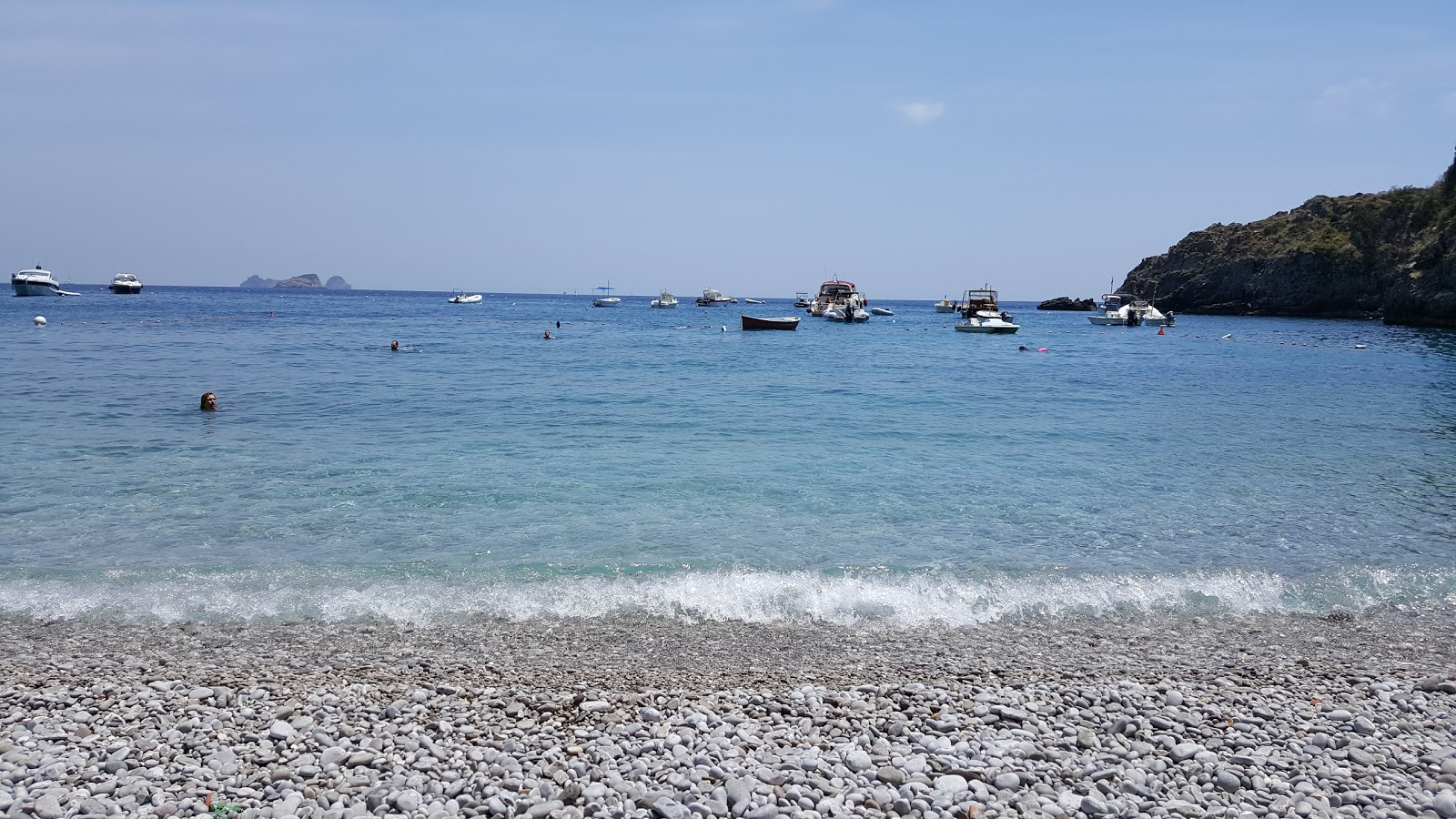 Foto van Spiaggia di Recommone omringd door bergen