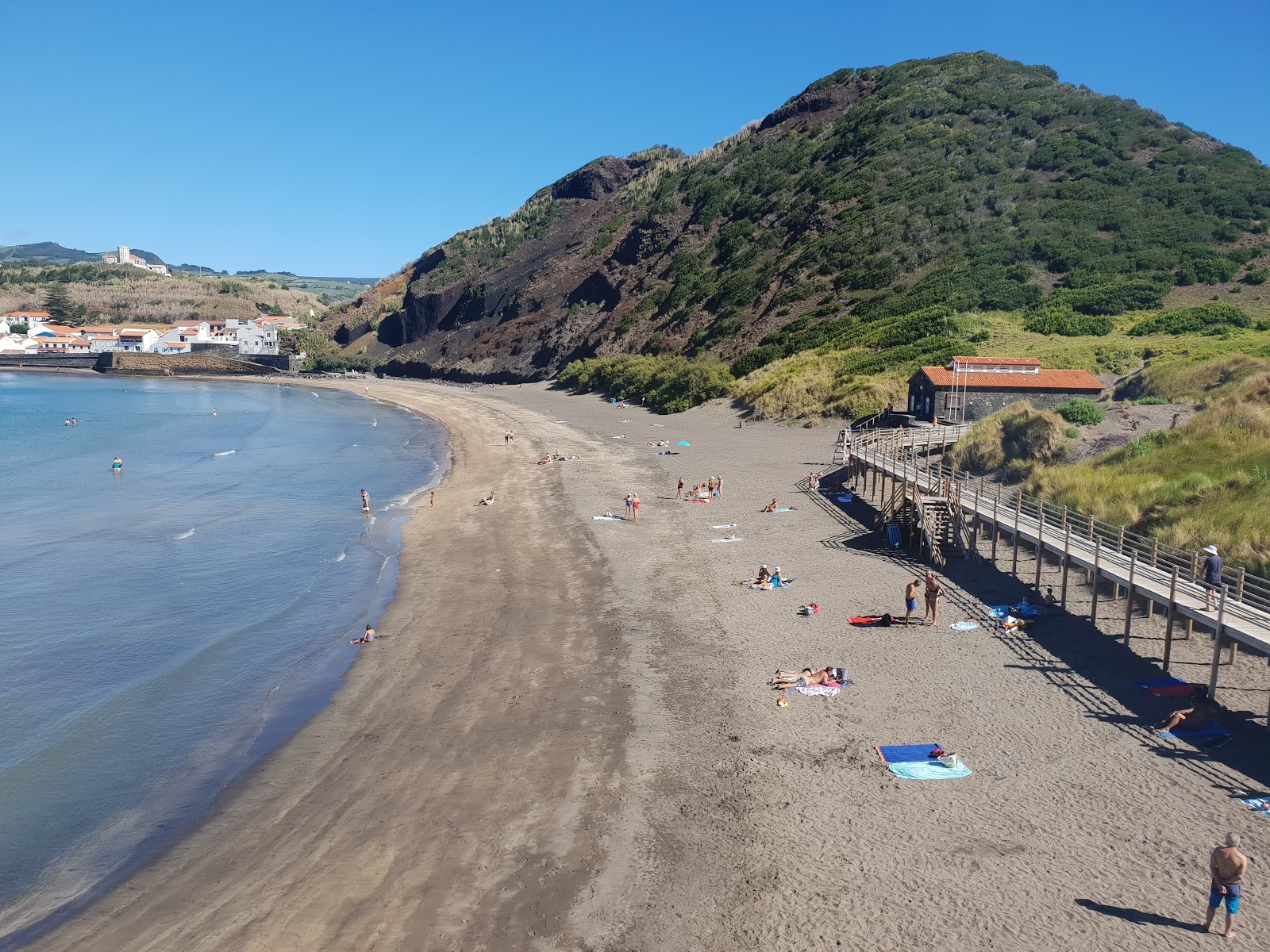 Foto af Praia do Porto Pim bakket op af klipperne