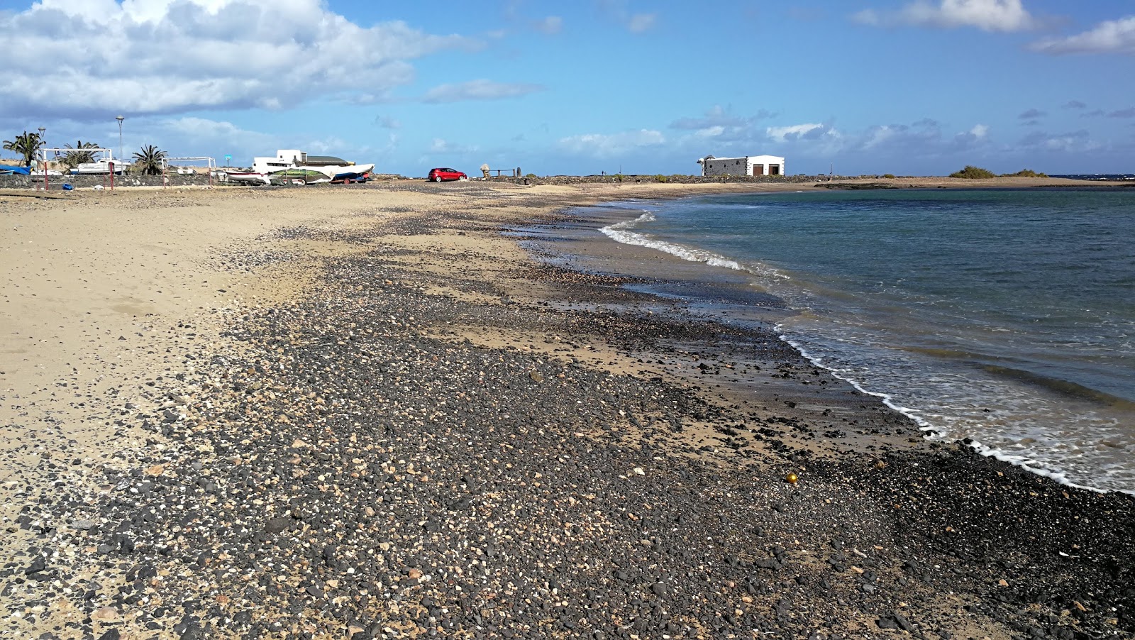 Photo de Playa del Muellito avec sable noir avec caillou de surface