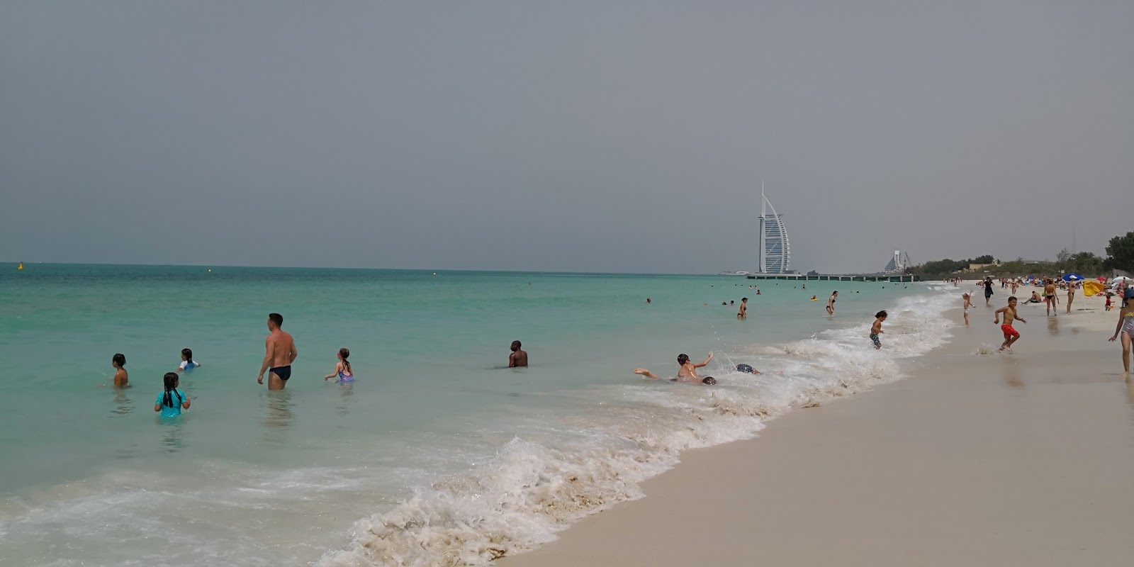 Valokuva Al Sufouh Beachista. pinnalla turkoosi puhdas vesi:n kanssa
