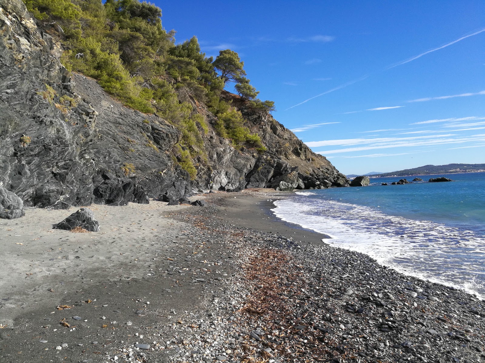 Valokuva Plage de Malpassetista. pinnalla harmaa hiekka ja kivi:n kanssa