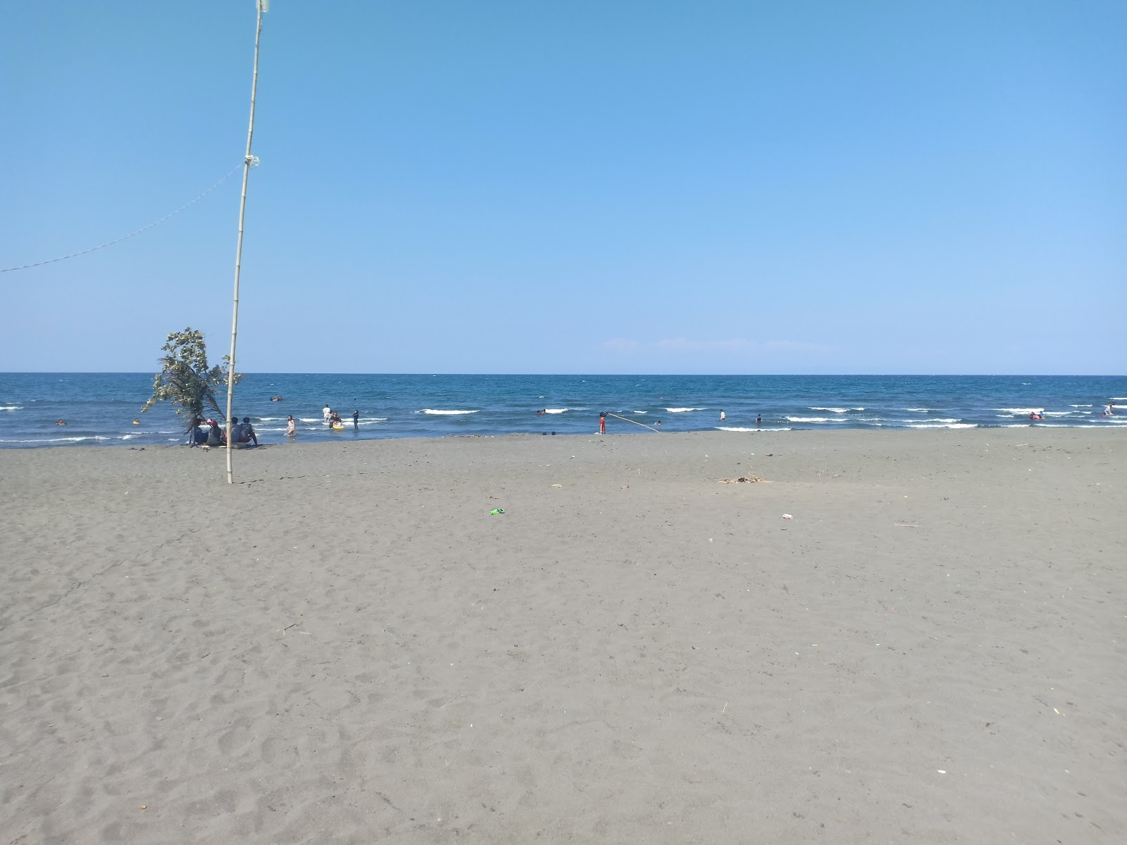 Foto di Pitugo Beach con una superficie del sabbia grigia