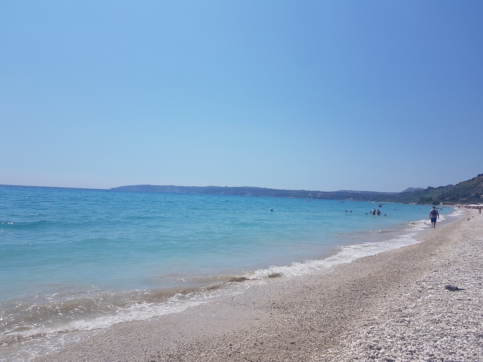 Foto av Lourdas beach med beige sand och småsten yta