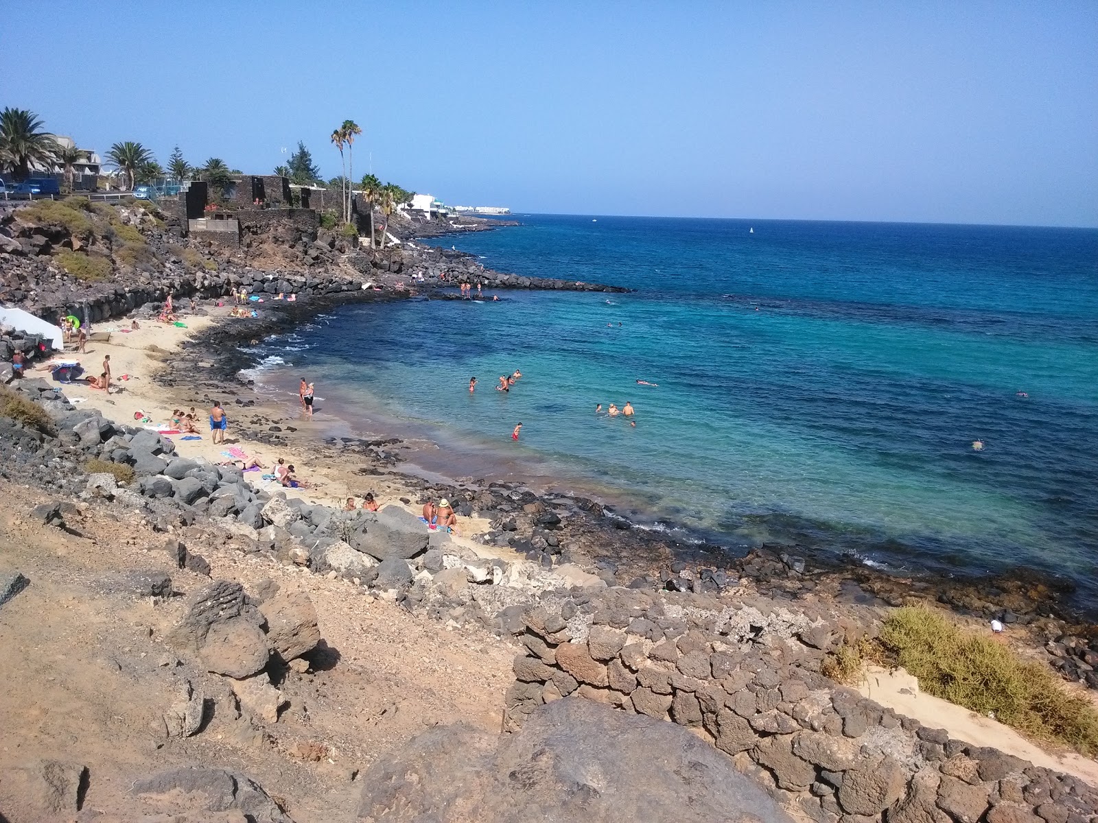Playa El Ancla'in fotoğrafı parlak kum ve kayalar yüzey ile