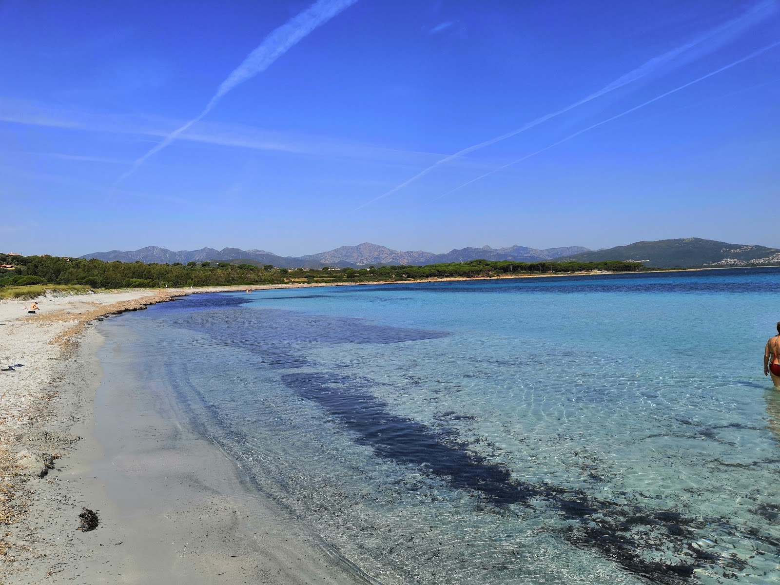 Foto van Spiaggia di Porto Ainu met helder zand oppervlakte