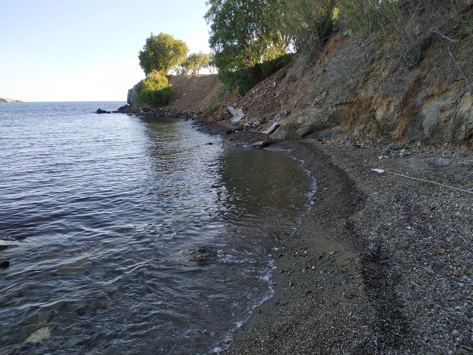 Foto de Paralia Agios Isidoros con arena gris y rocas superficie