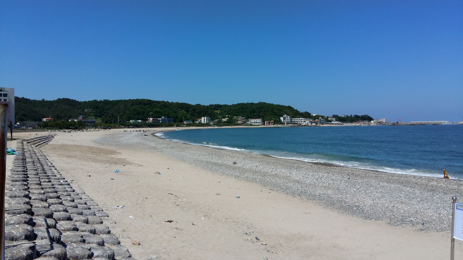 Foto av Gwanseong Beach med harmaa hiekka ja kivi yta