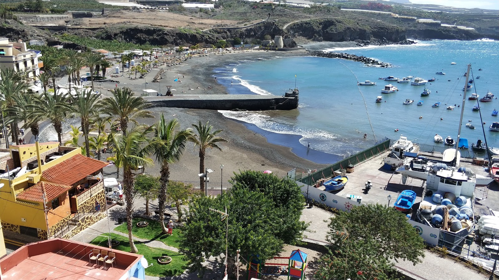 Foto av Playa San Juan med harmaa hiekka ja kivi yta