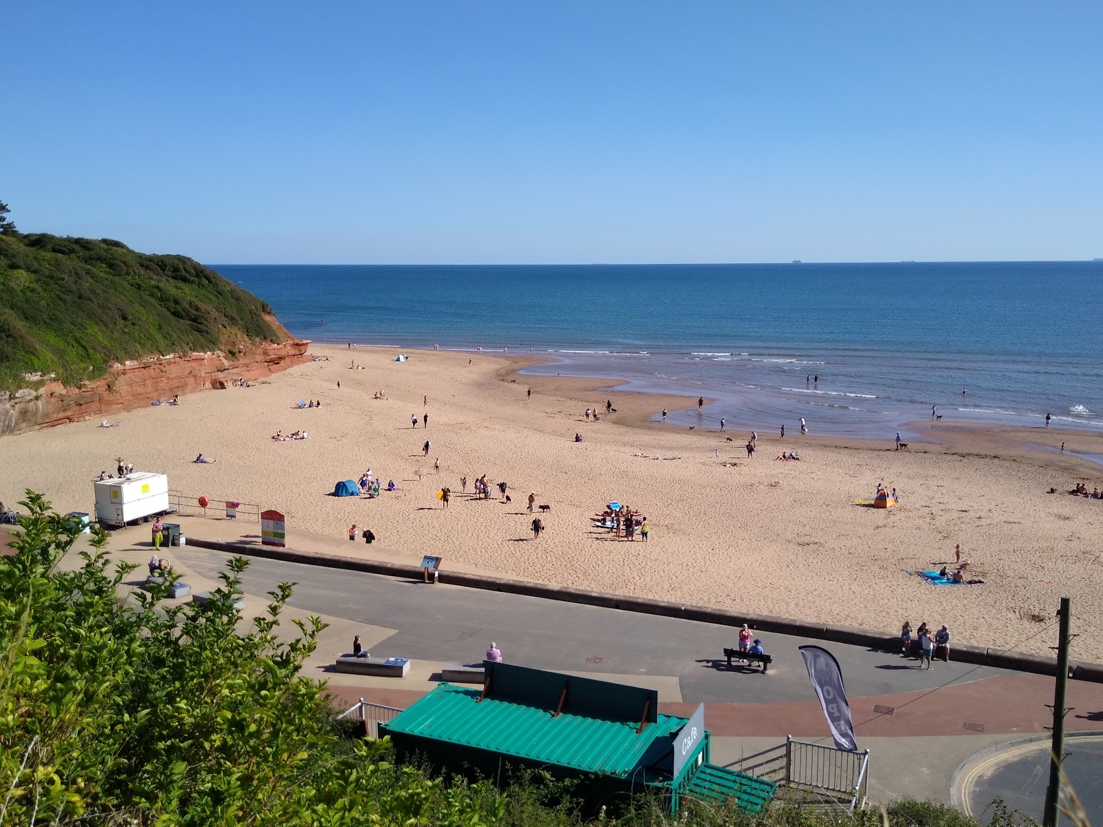 Foto van Green fields beach met bruin zand oppervlakte