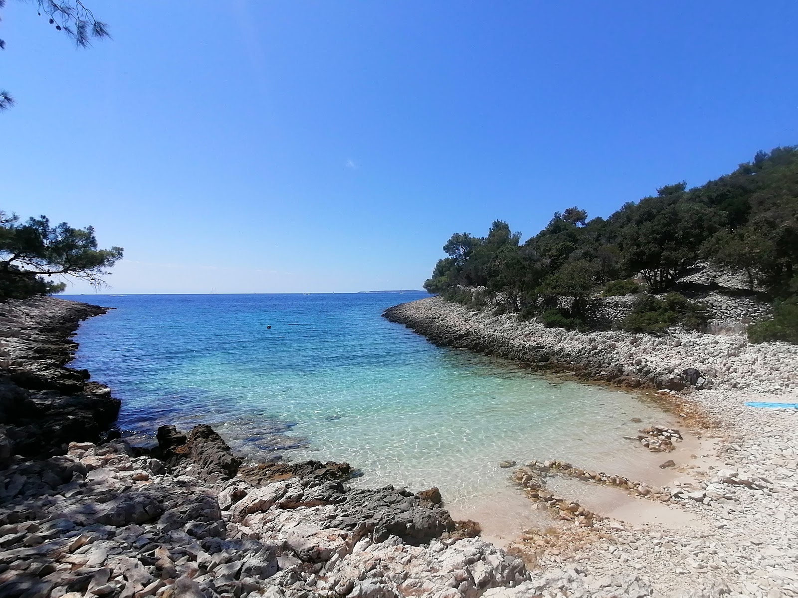 Foto von Cuanguski Zaljev mit beiger sand & kies Oberfläche