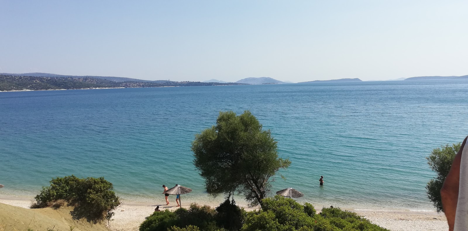 Foto von Agios Georgios Beach umgeben von Bergen